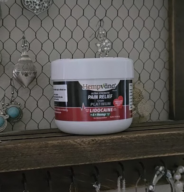 Hempvana Platinum Pain Relief Cream with lidocaine and hemp, styled on a rustic wooden shelf with chicken wire backdrop.